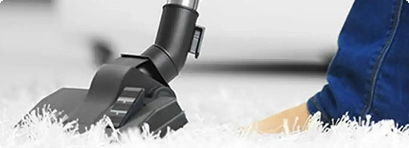 Close-up of a professional vacuuming a white carpet in Marion.